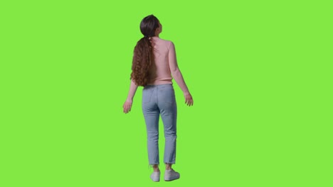 Full-Length-Studio-Shot-Of-Woman-With-Amazed-Expression-Looking-All-Around-In-VR-Environment-Against-Green-Screen-1